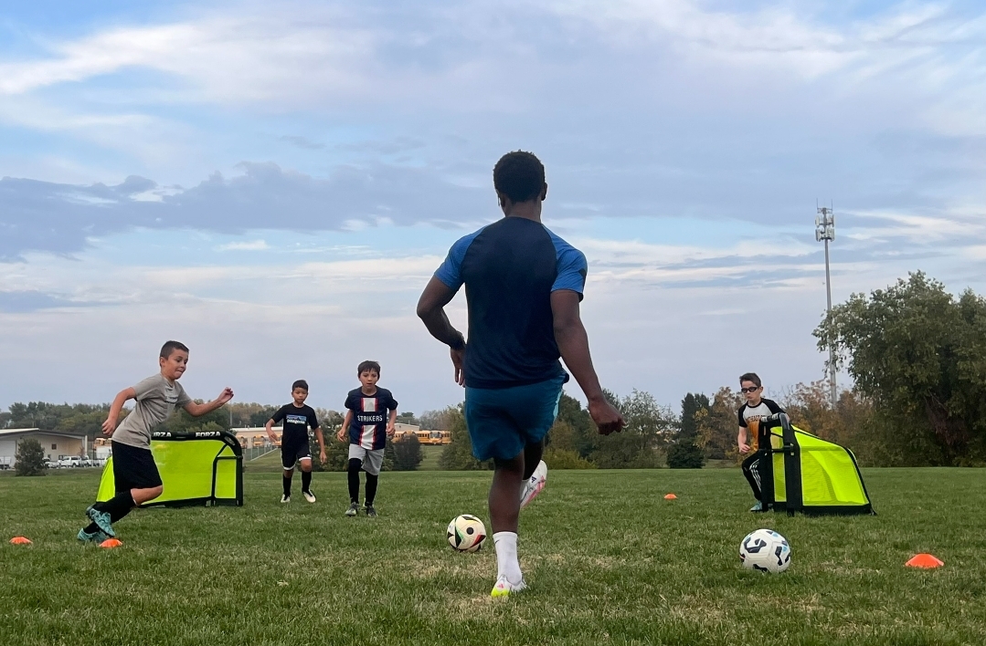 Coach leading an outdoor finishing session with young players